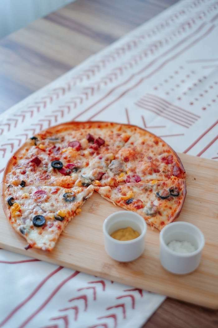 A delicious pizza with varied toppings served on a wooden board, perfect for dining settings.